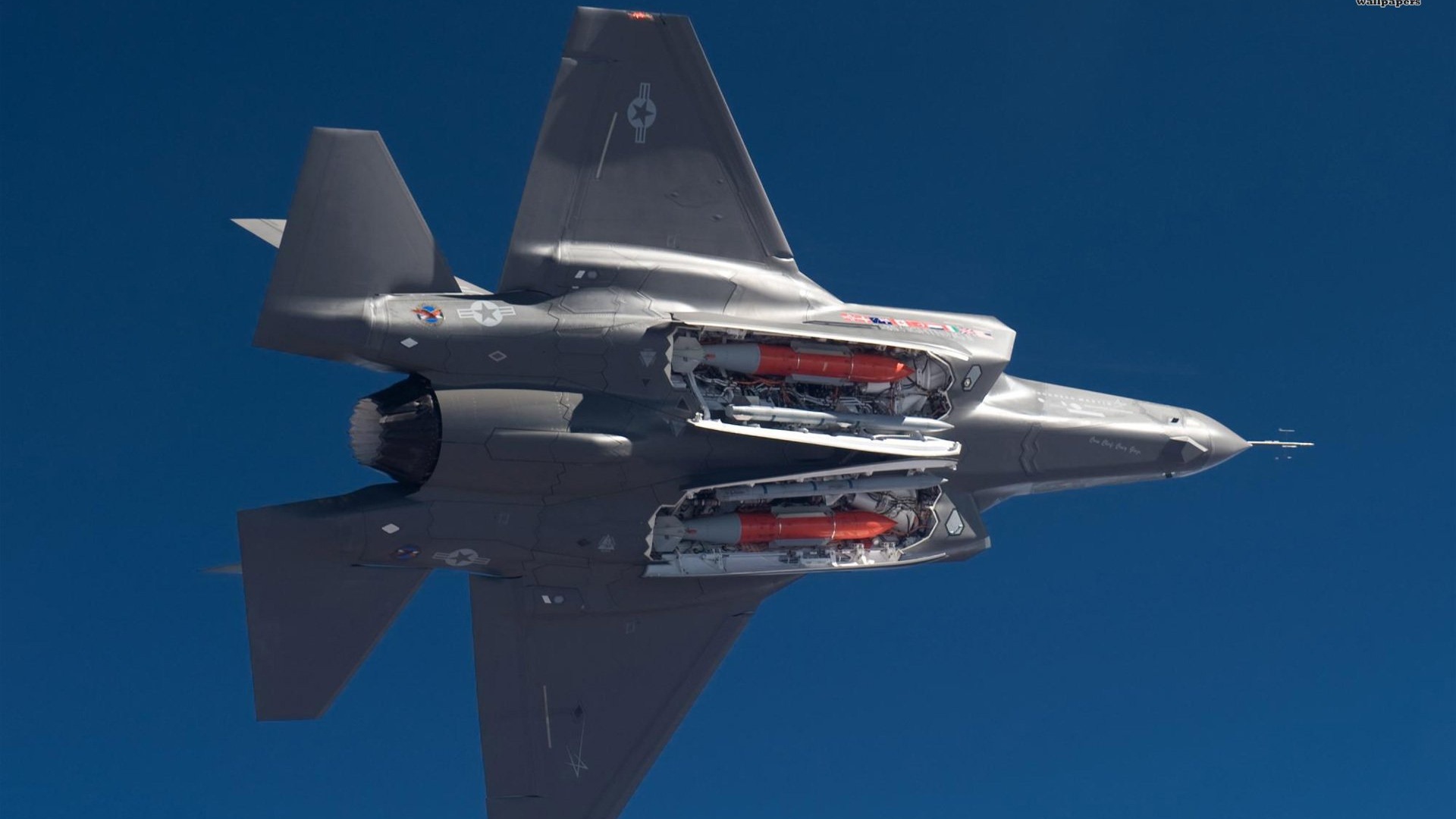 F-35战斗机在蓝天中飞行，弹舱开启露出挂载导弹