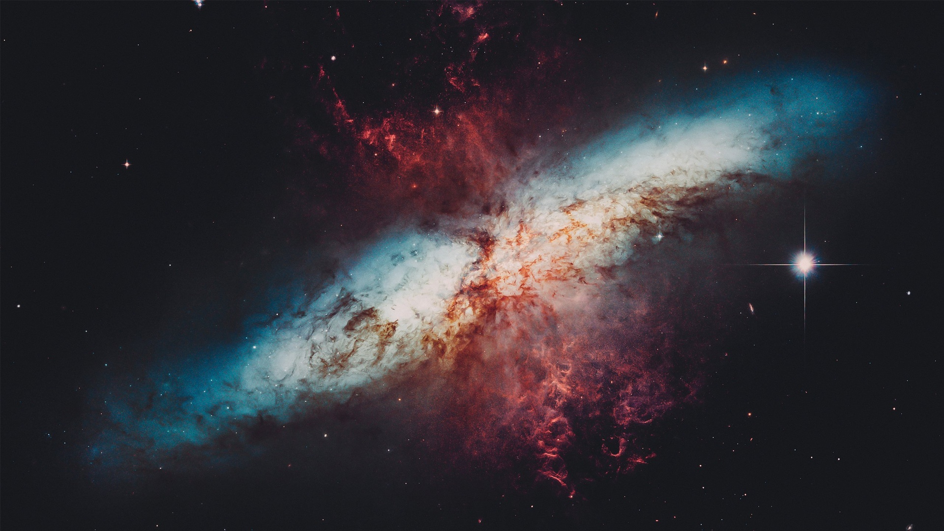 纯黑深空背景上的彩色弥散星云，青蓝、红棕与暖白交织，密集星点散布。