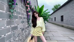 小巷墙角摆拍的长发美女