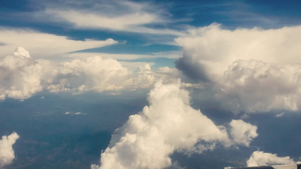 航空视角拍摄的高空积云，蓝天下层叠分布的白云与朦胧远景