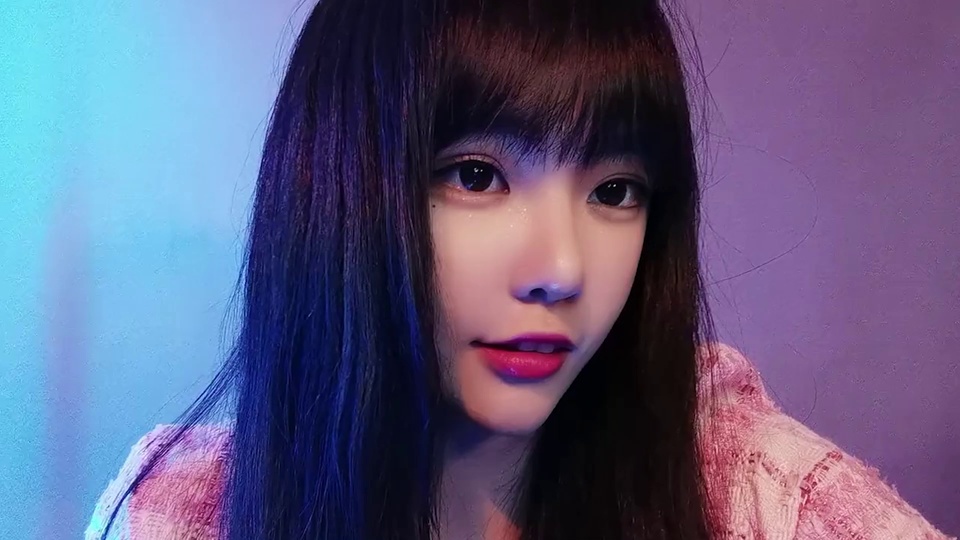 蓝紫渐变霓虹背景前的齐刘海长发女生近景肖像