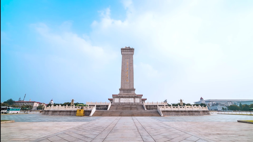 低角度拍摄的广场纪念碑，周围是空旷石板广场与淡蓝晴空。