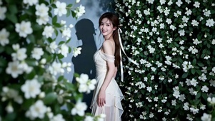 在花坛拍照的长发美女