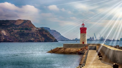 阳光洒在大海尽头的灯塔上