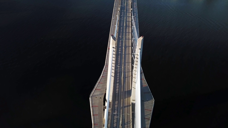 高空俯视的白色斜拉桥横跨深色水面
