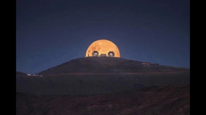 一轮圆月山头浮现