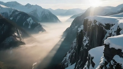 日出晨雾积雪山谷