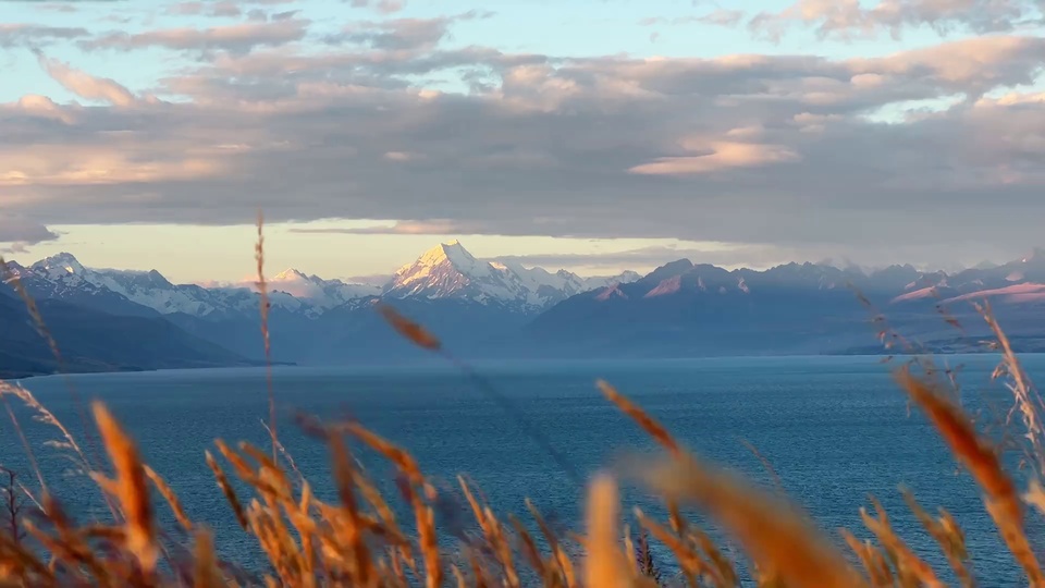 暖光枯草前景的雪山湖泊夕照风光