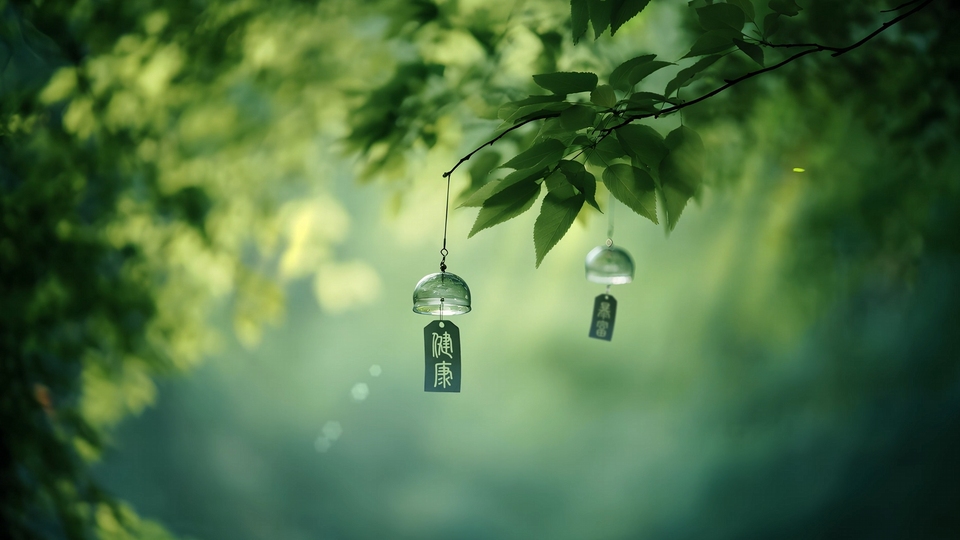 悬挂在绿叶细枝上的两枚玻璃风铃