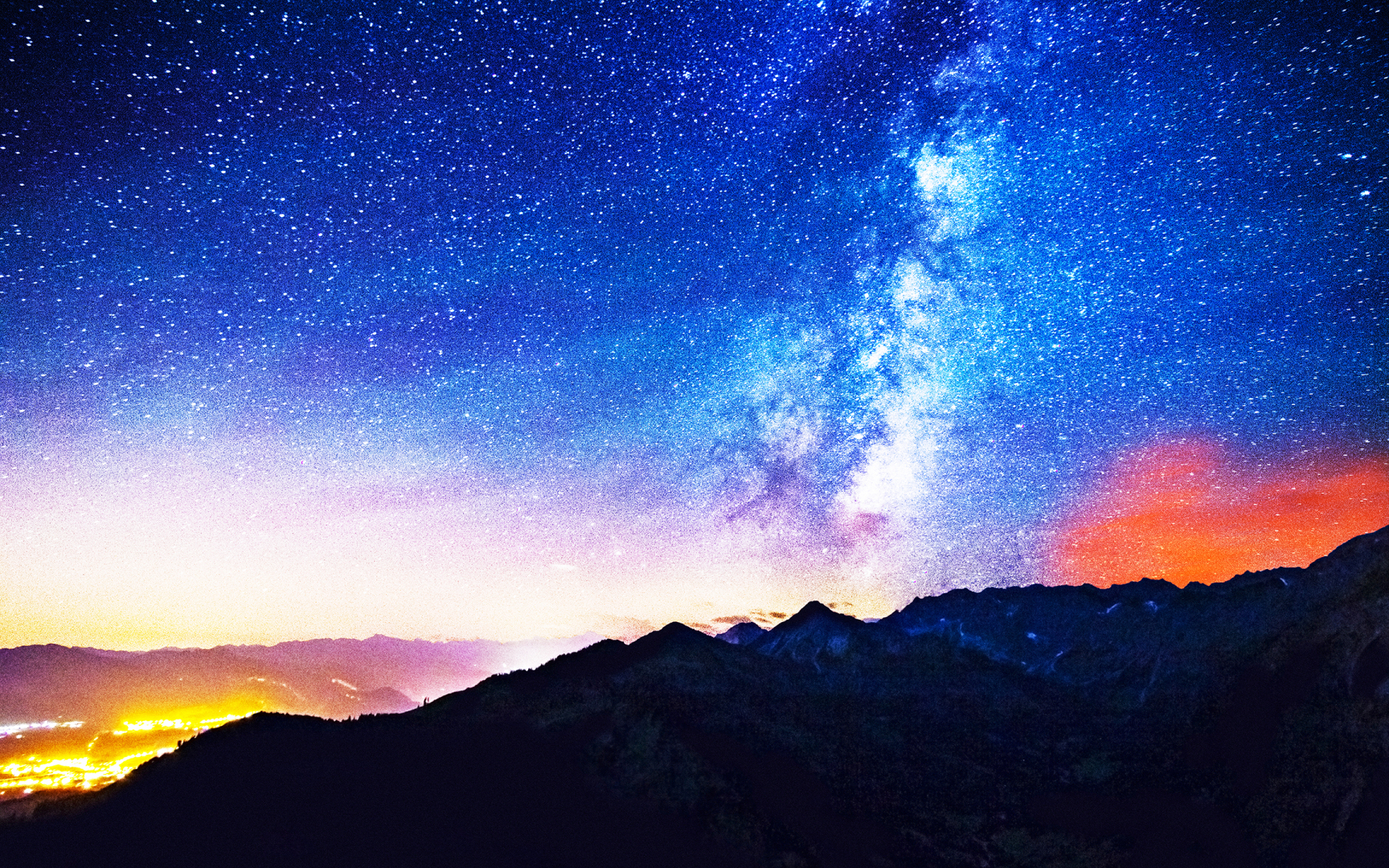 写实摄影风格山野夜景，上半部分是布满繁星与清晰亮白色银河的渐变夜空，底部是深色连绵山脉剪影，山谷间散落着城市暖黄色灯火。